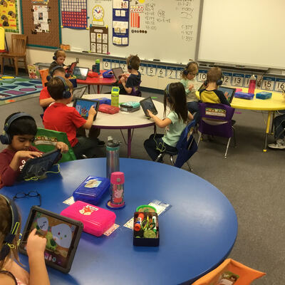 Kindergartners using headphones purchased through an Appleseed Grant