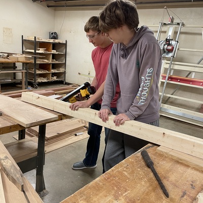 Two Sabetha students working together using a new tool in shop class.