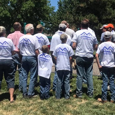 Volunteers showing their Neighbor-2-Neighbor t-shirts while working on a project