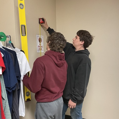 Wood Class Students measuring area for shelves.